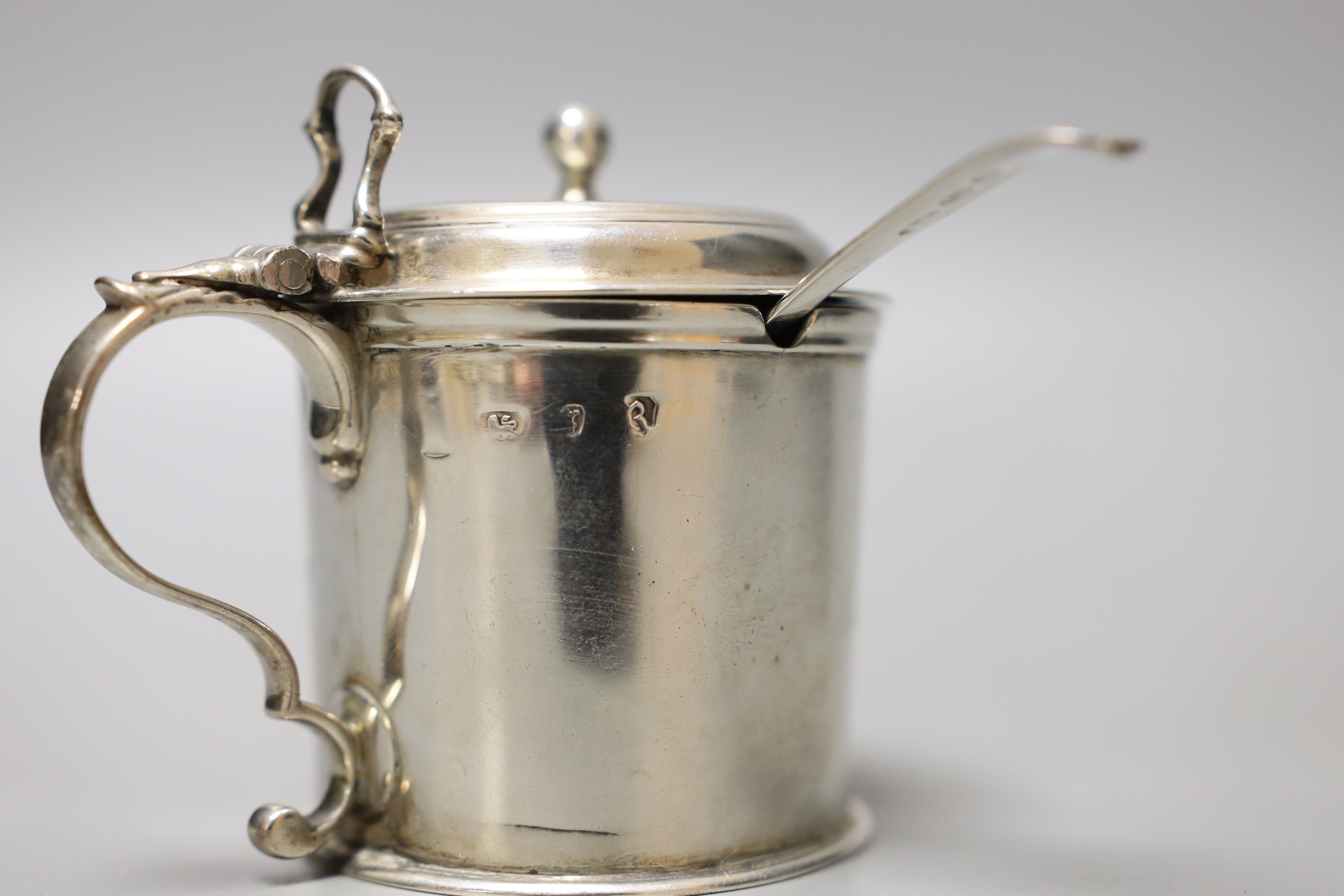 A George III silver drum mustard pot, London, 1772, height 71mm, with later associated silver spoon.